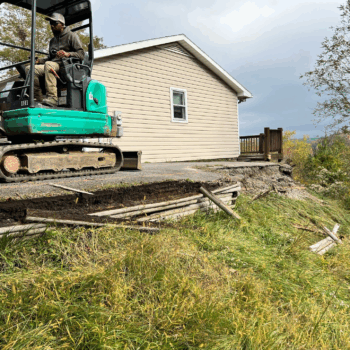 Excavator repairing eroded driveway edge